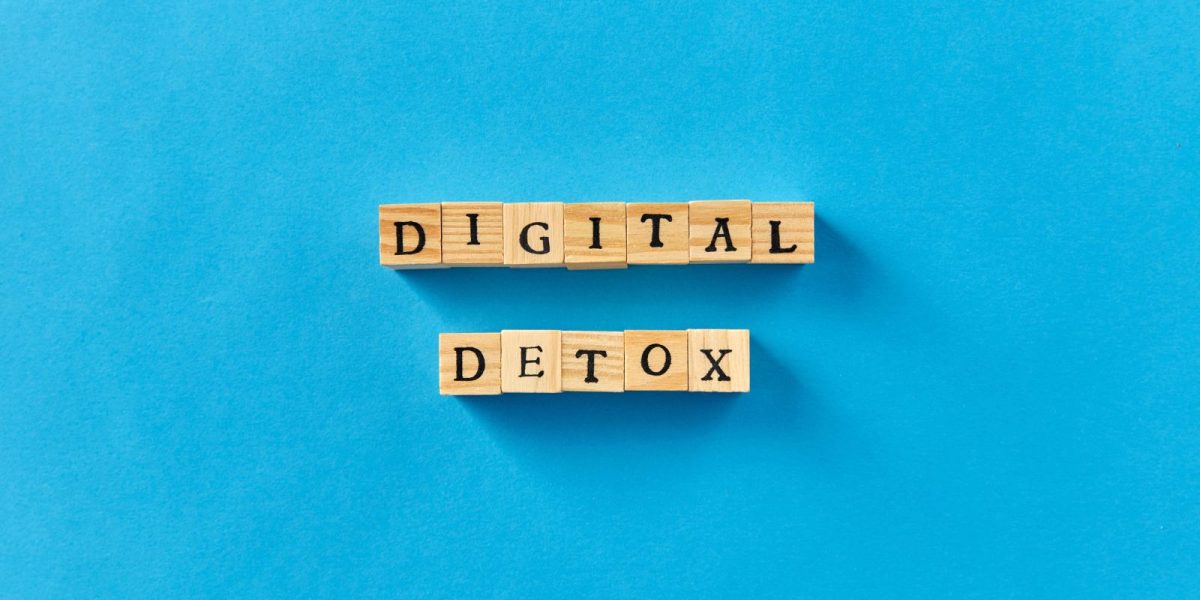 Digital Detox auf Holzblöcken geschrieben auf blauem Hintergrund
