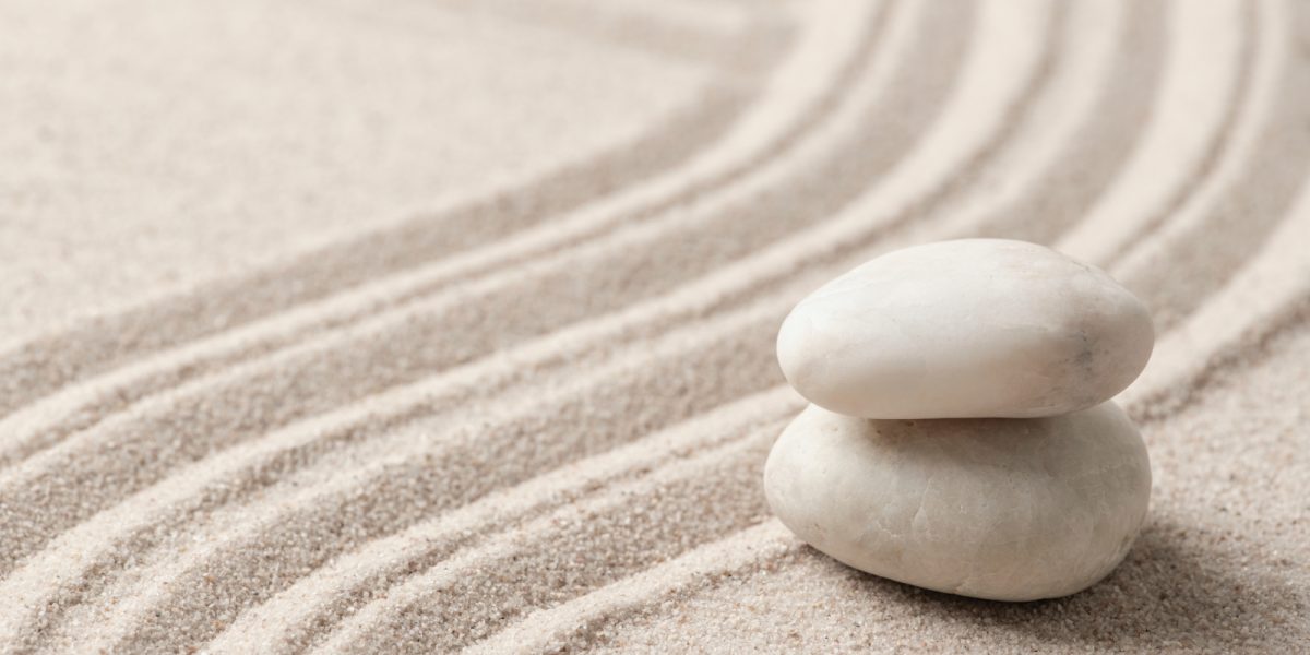 zwei Steine liegen aufeinander im Sand