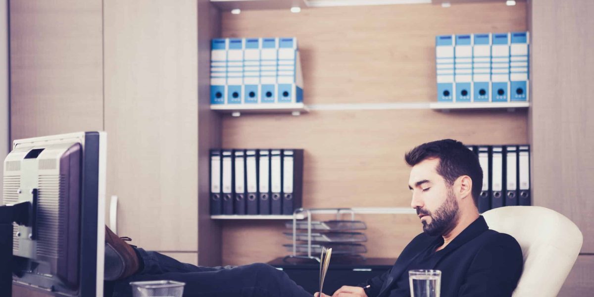 Young tired Businessman working in his office. Businessperson in professional environment